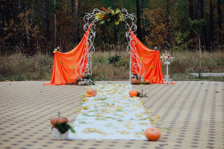 beautiful wedding arch made of cloth with autumn decorationsの写真素材