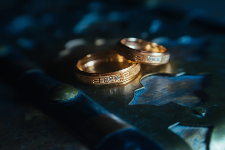 Beautiful wedding golden rings on dark background .