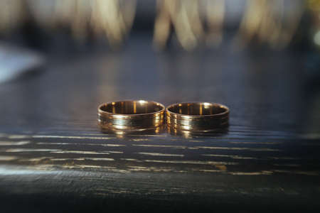 Beautiful wedding golden rings on dark background .の写真素材