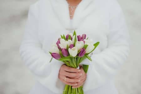 wedding bouquet of tulips in hands of the bride winterの写真素材