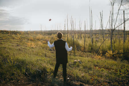 magician in a suit with cards at sunsetの写真素材