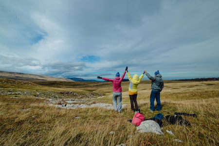 three tourists on the background of mountain sceneryの写真素材