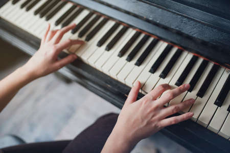 The girl plays piano, close up , white and black keyboardの写真素材
