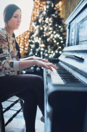 girl playing on an old piano vintageの写真素材
