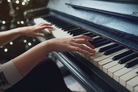 Hands on an old antique piano. Close-upの写真素材