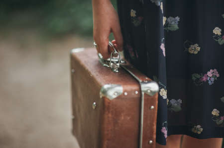 girl in a vintage dress holding suitcaseの写真素材