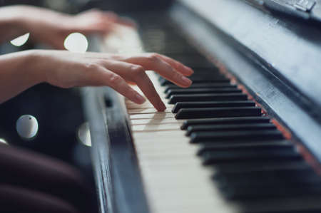 girl playing on an old piano. Beautiful blur backgroundの写真素材