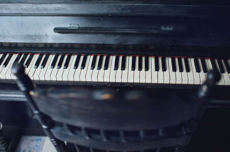 Black antique piano and a chair. General formの写真素材