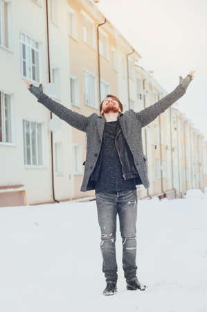 stylish man raised his hands up against the houseの写真素材