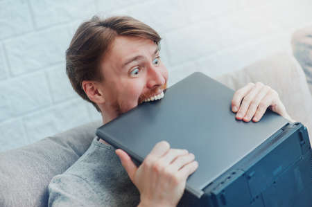 stylish man with a laptop on the sofa at homeの写真素材
