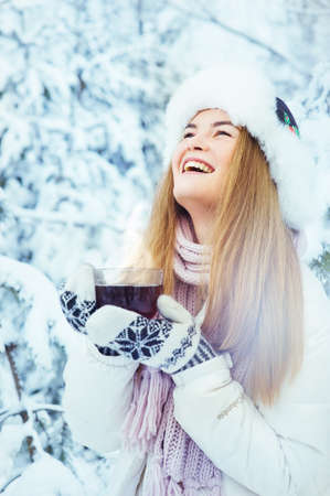 beautiful girl with a cup of coffee in the winterの写真素材
