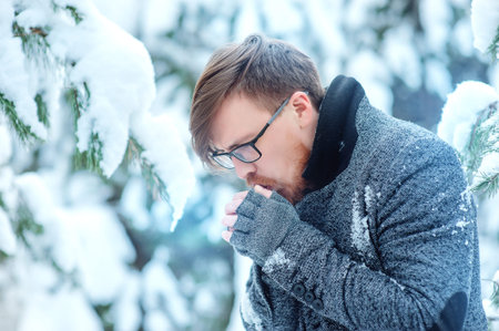 Fashion portrait handsome elegant bearded man in the winter forest