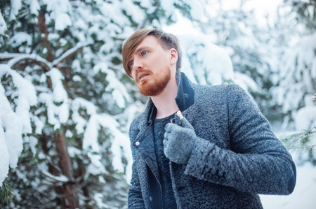 Fashion portrait handsome elegant bearded man in the winter forest