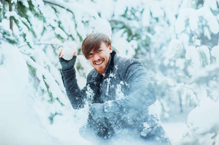Stylish man with a beard playing snowballsの写真素材