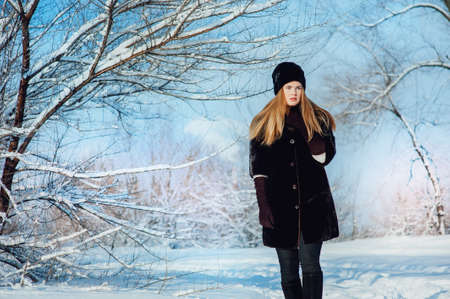 Outdoor waist up portrait of young beautiful fashionable woman posing on streetの写真素材