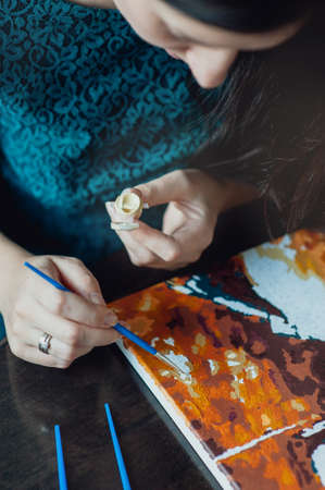 young beautiful girl with long hair draws a picture paintsの写真素材