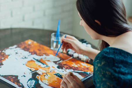 beautiful girl in dress draws a picture paintsの写真素材