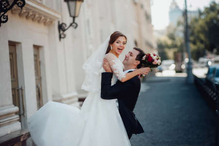 the bride and groom on the background of urban architectureの写真素材