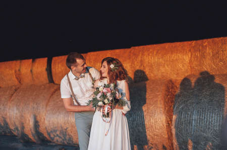 Bride and groom on background of hayの写真素材