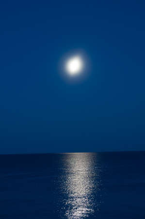 Moon in the night sky in the background of the seaの写真素材