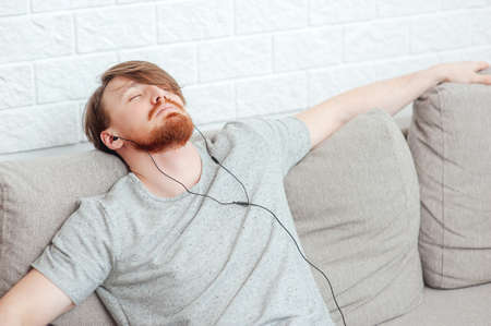 man with beard listening to player and restingの写真素材