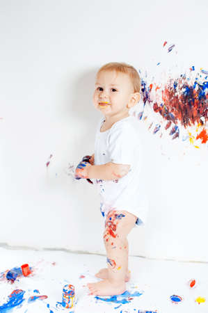 Little baby boy covered in paint for paintingの写真素材