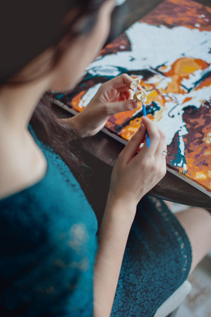 girl in a blue dress draws picture paints