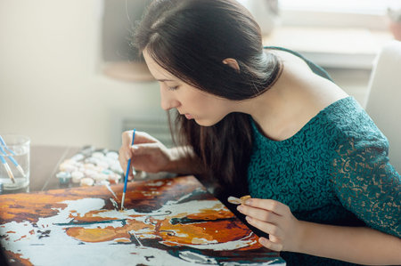 beautiful girl in dress draws a picture paints