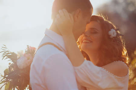 the bride and groom on a lake the background of beautiful sunsetの写真素材