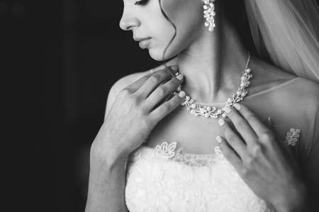 beautiful bride in a white dress holding a necklaceの写真素材