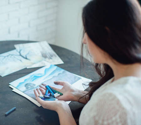 Woman holding crayons in front of her face.の写真素材