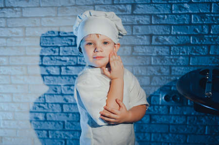 Child with kitchen spoon, dressed as a cookの写真素材