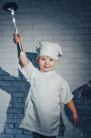 Child with kitchen spoon, dressed as a cookの写真素材