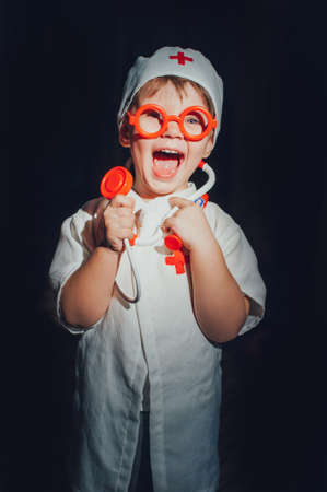 Child dressed doctor on a dark background. isolatedの写真素材