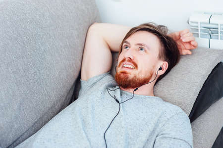 man with beard listening to player and restingの写真素材