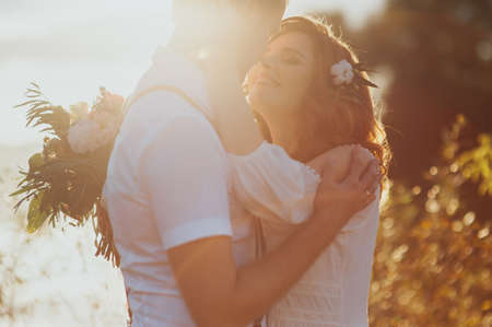 the bride and groom on a lake the background of beautiful sunset