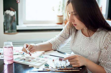 girl painter in white dress draws paintsの写真素材