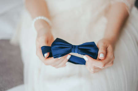Butterfly tie in the hands of the brideの写真素材