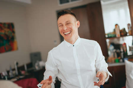 Stylish handsome groom in a white shirt laughingの写真素材