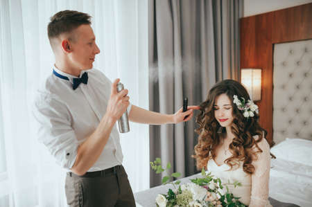 Wedding brides preparations. Work stylist. Aerosol sprayingの写真素材