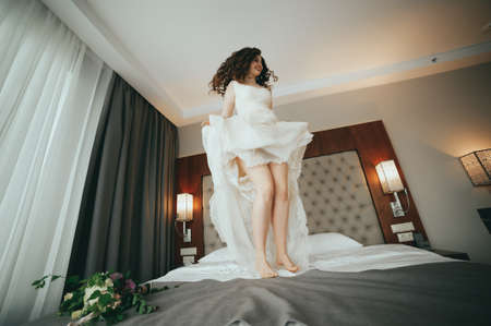 Stylish bride tosses the dress on the bedの写真素材
