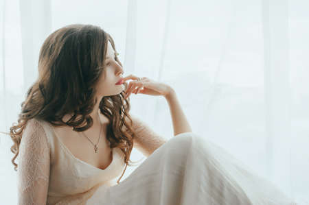 The bride posing against the window. light backgroundの写真素材