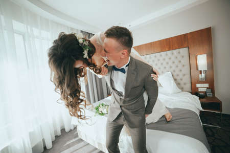 bride and groom having fun in bedの写真素材