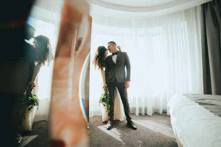 The bride and groom on the window backgroundの写真素材