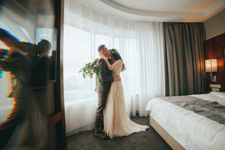 The bride and groom on the window backgroundの写真素材