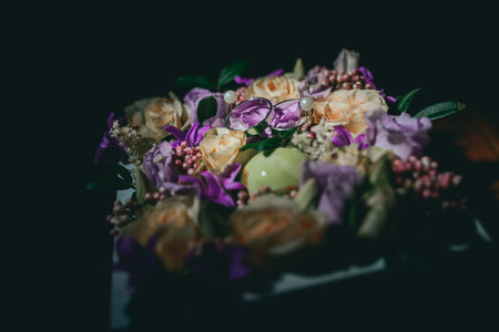 Two gold wedding rings on a cushion of flowers