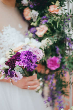 Stylish beautiful bride holds a wedding bouquet in handsの写真素材