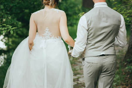beautiful gorgeous blonde bride and stylish groom, on the background of a seaの写真素材