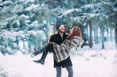 loving couple having fun in the snowy forestの写真素材