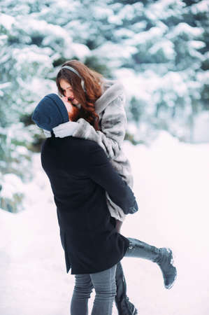 Cute young hipster couple having fun in winter parkの写真素材